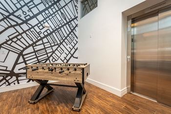 a foosball table in a room with an elevator at Union 346, Somerville, MA 02143